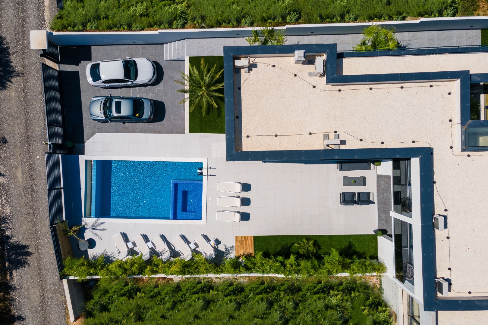 Aerial drone view of the villa, pool, and driveway